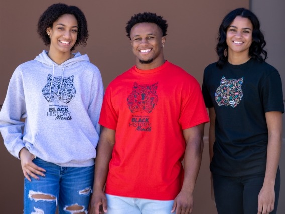 three students wearing shirts featuring the black history month logo
