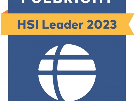 A blue, flag-shaped emblem with a yellow banner across the center. THe top of the emblem reads &quot;Fulbright&quot; in capital letters, and the banner reads &quot;HSI Leader 2023.&quot;