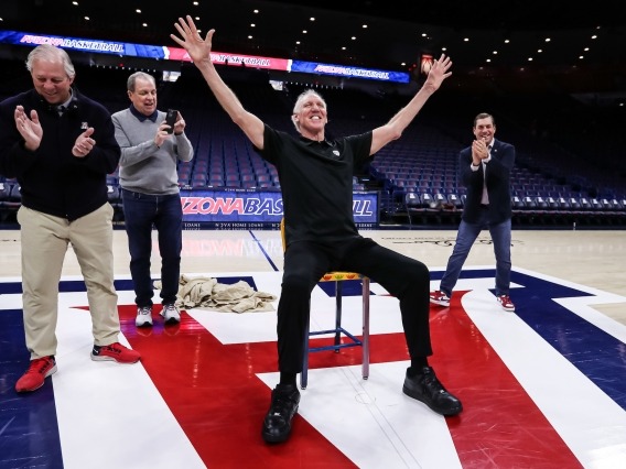 Bill Walton sitting on a chair with arms extended