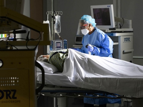 a doctor standing next to a patient lying on a bed